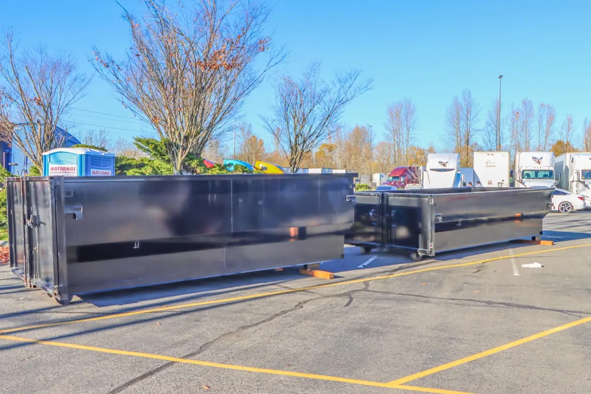 Professional dumpster rental service with roll-off container on residential driveway in Pierre